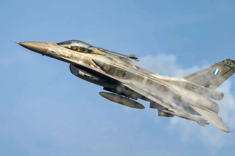 the fighter jet flies sideways across a blue sky