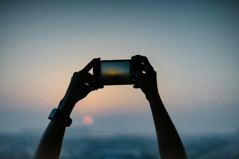 two people holding up a camera at the camera