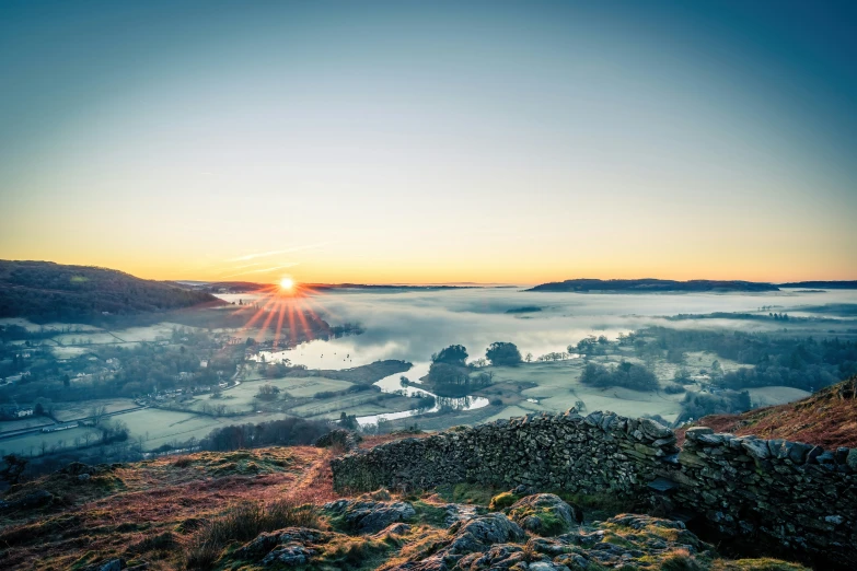 the sun is shining through the sky above some fog