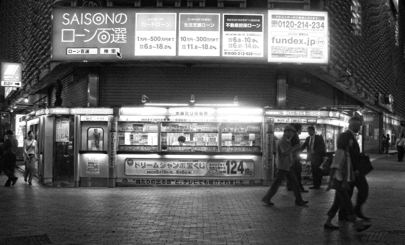 a group of people standing next to a food stand