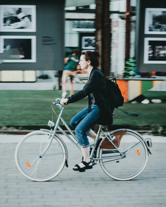 a woman riding a bike in front of a green field