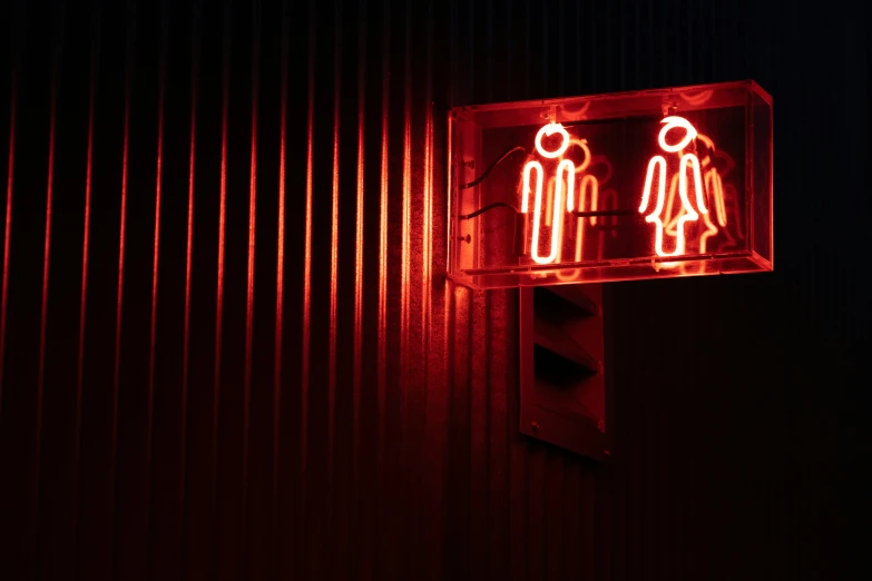 a red traffic signal that has a sign of two people in the center of the image