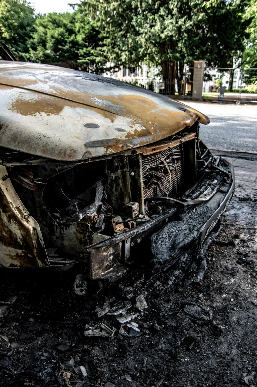 the burned car is sitting in the street