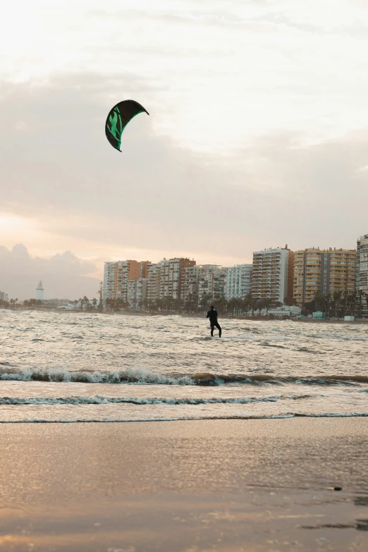 a man standing in the ocean flying a kite