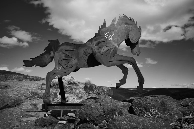 a horse sculpture on a hill with the sky in the background