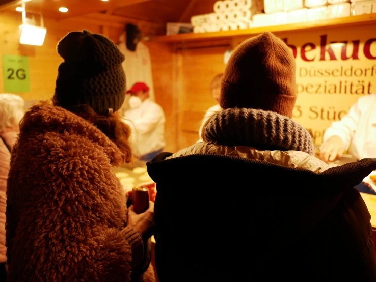 two people watching soing while standing in front of a tv screen