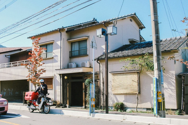 motorcycle parked at an intersection in front of a very old apartment building