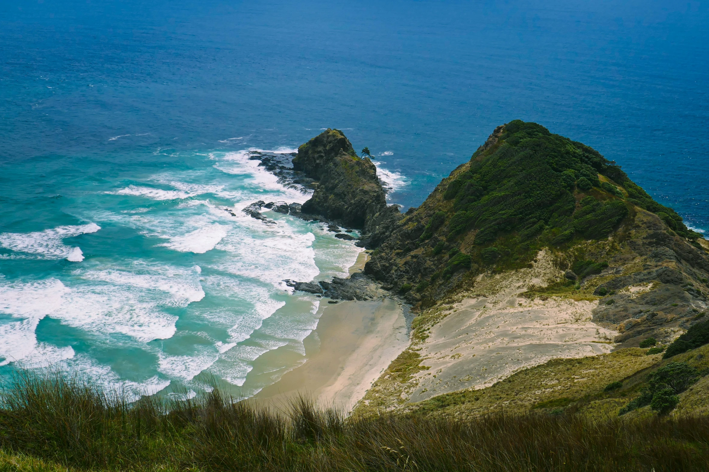 an ocean shore with several rocky outcrops and a body of water