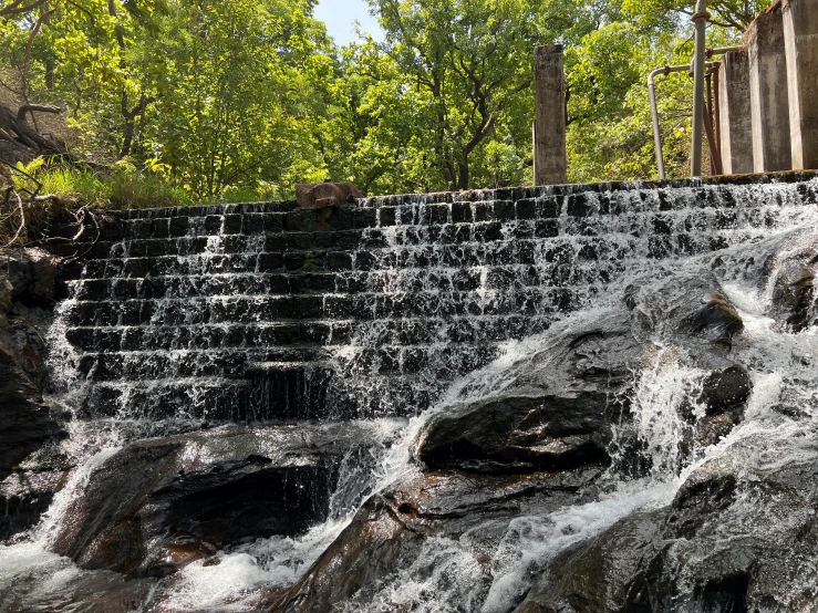 a man sits on the top of a waterfall