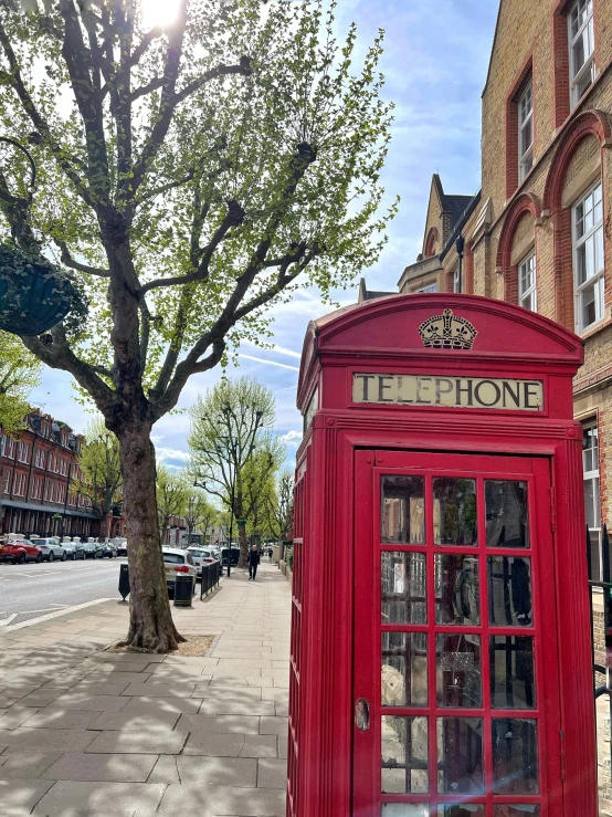 a red phone booth on the side of a road