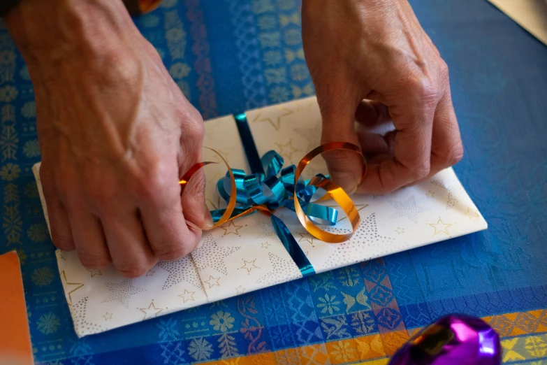 a person tying a piece of ribbon on a piece of paper