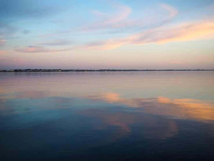 water in front of a pink sky that reflects its colors