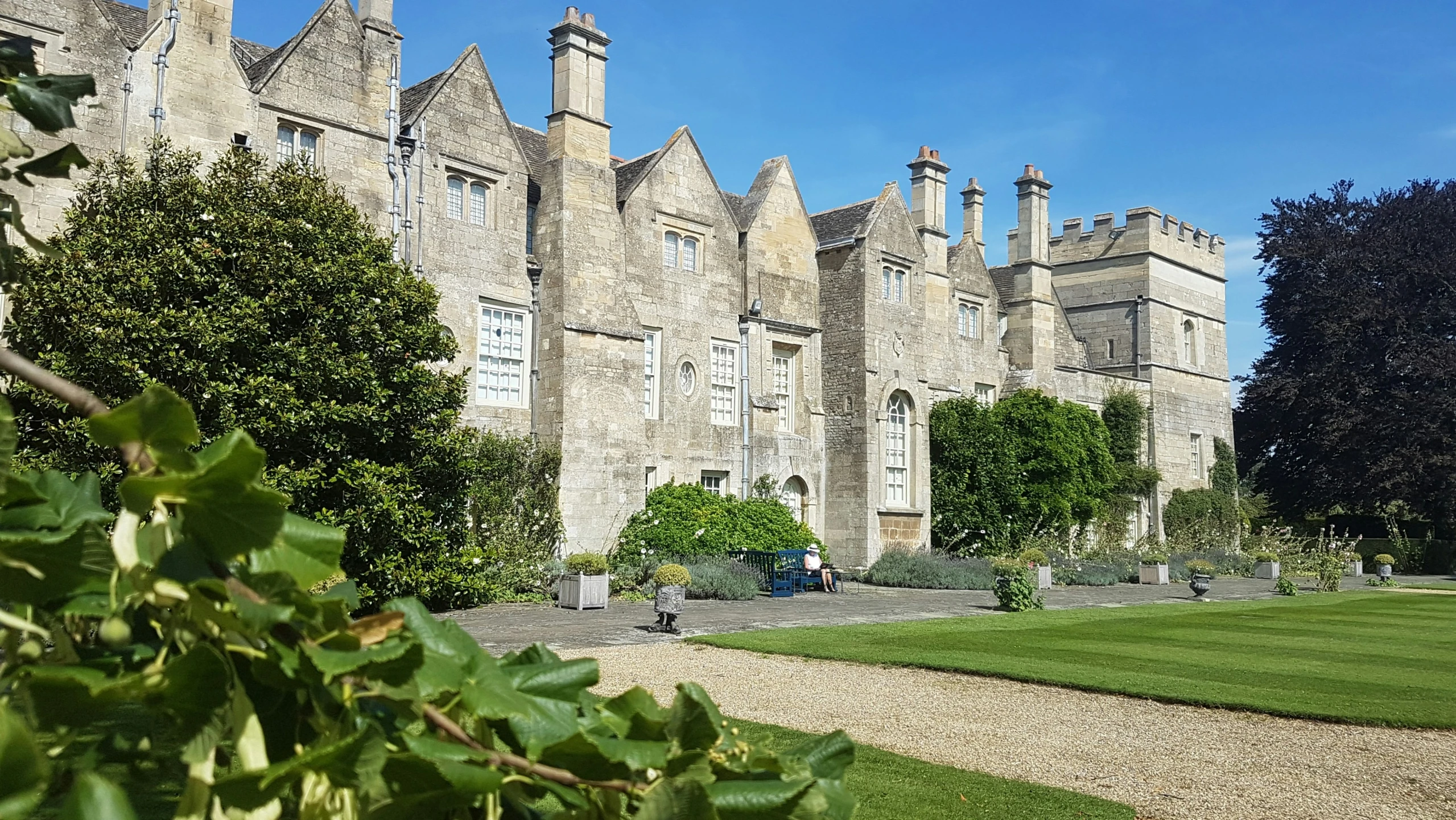 the large stone building has many trees and bushes around it