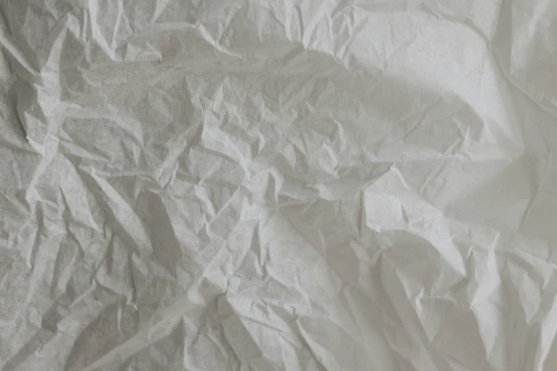 a white background of crumpled paper has several small patches of paint