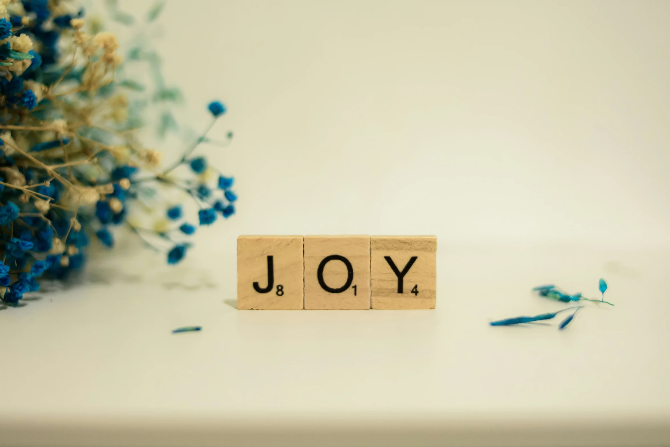a small wood block that says joy on it