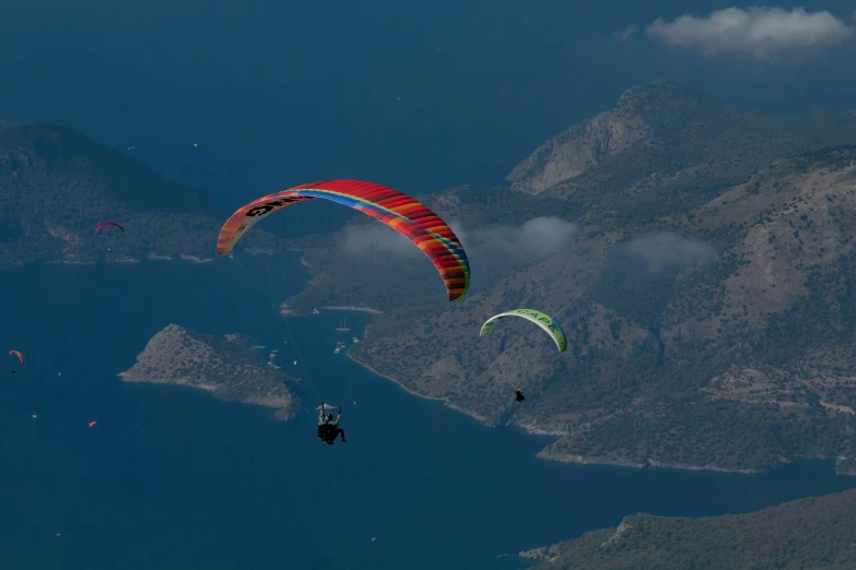 people are flying their kites over the mountains