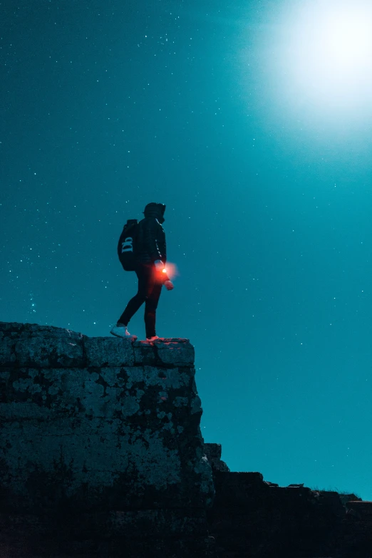 a man in dark clothes walking up a hill