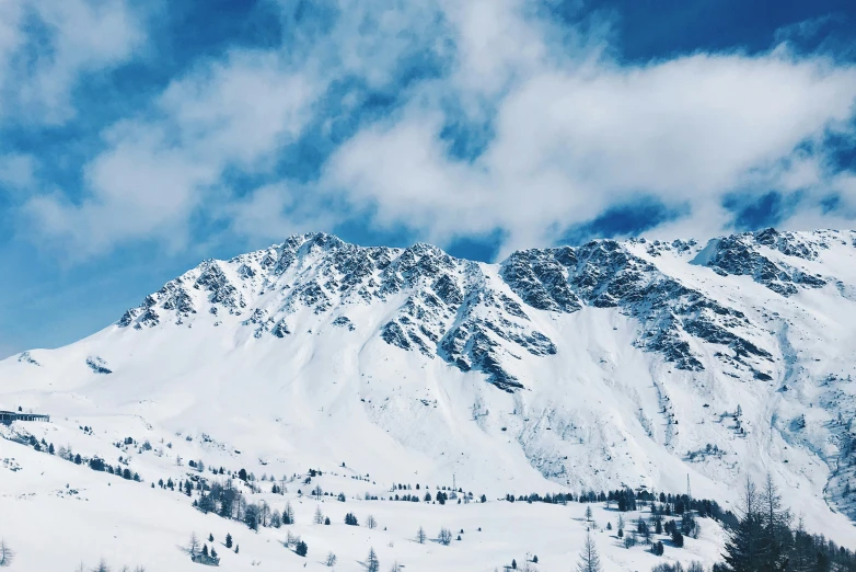 snow covered mountains sit in the middle of an open field