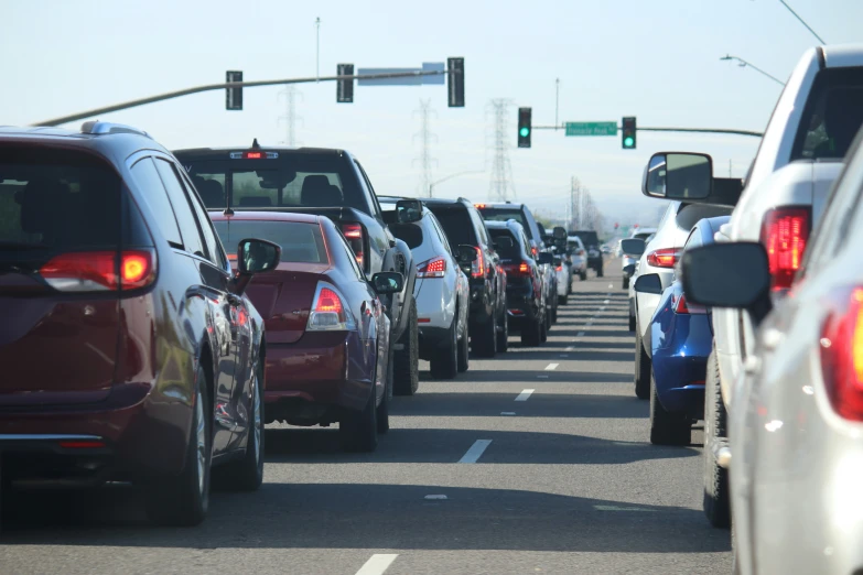 a large group of vehicles are driving down the street