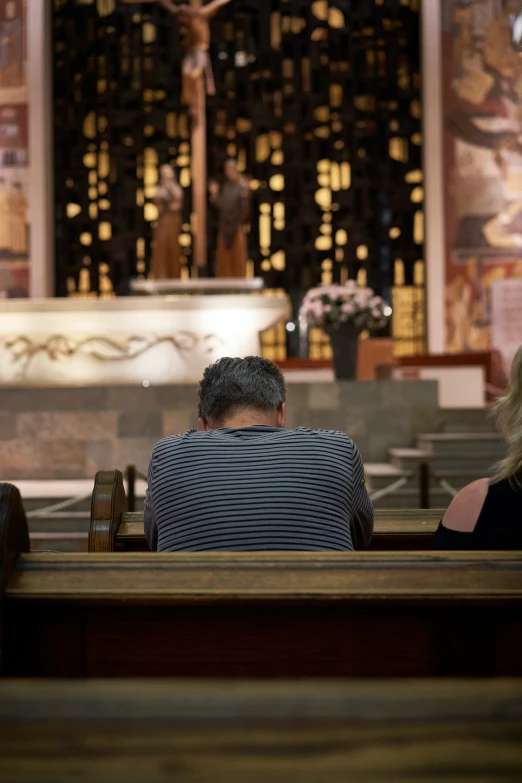 two people sitting in the back of a church