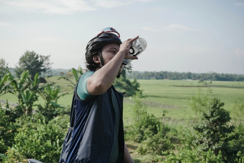 a man holding a water bottle with a horse in the background