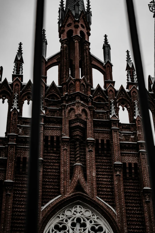 a view of a large, old brick church through the side bars