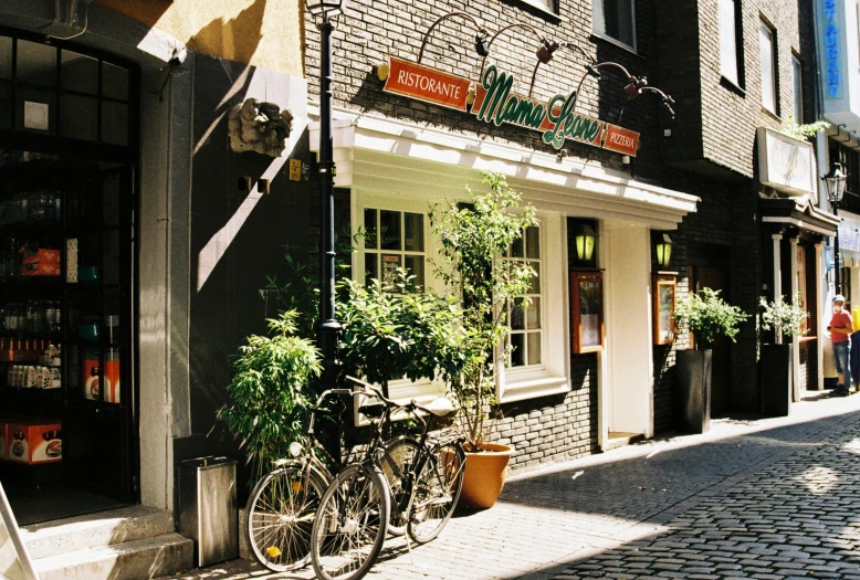 bicycles are parked in front of stores on an urban street