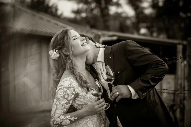 a bride and groom kiss outside their home