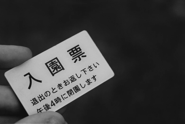 the man is holding up a business card with chinese words