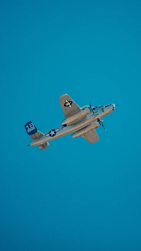 an old airplane flying through the blue sky