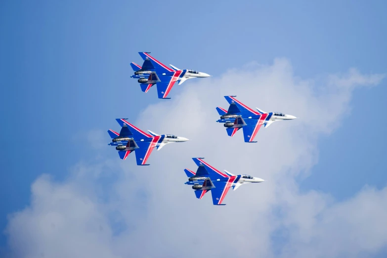 four red, white and blue jet jets flying in formation