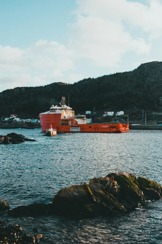 a large orange and white ship sitting at a small dock