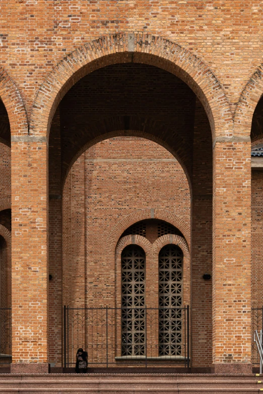 a stone building with a gate between it and a bicycle parked in front