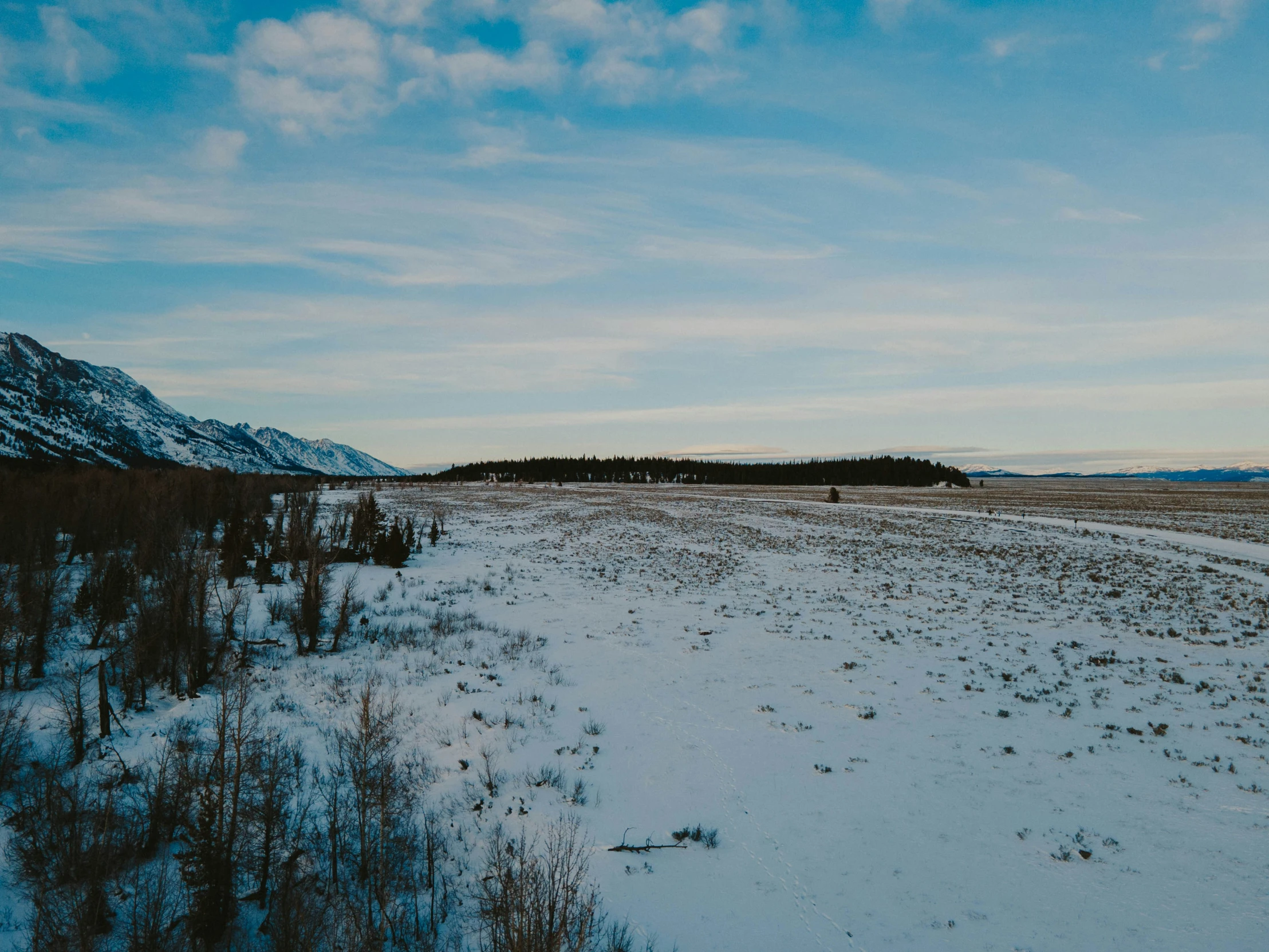 there is snow covered ground and blue skies in the sky