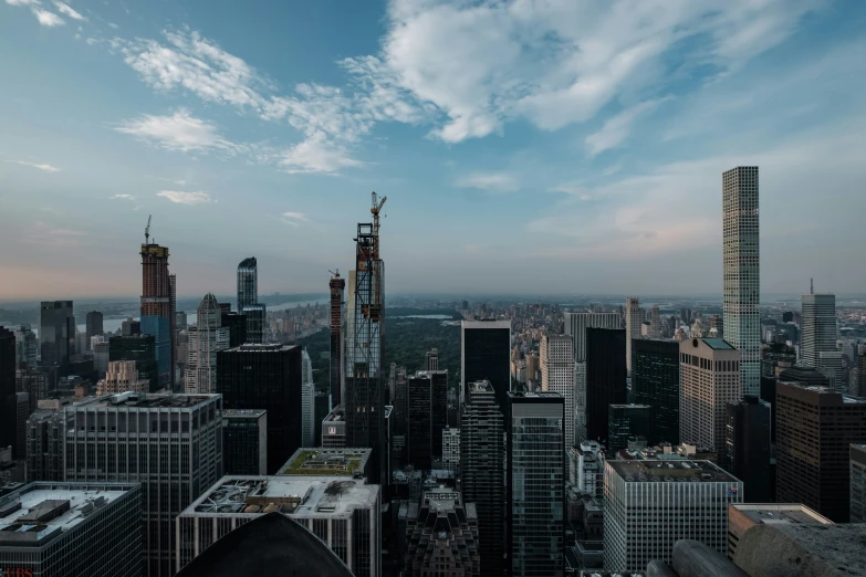 an aerial view of skyscrs in a city, in the distance is a very cloudy sky