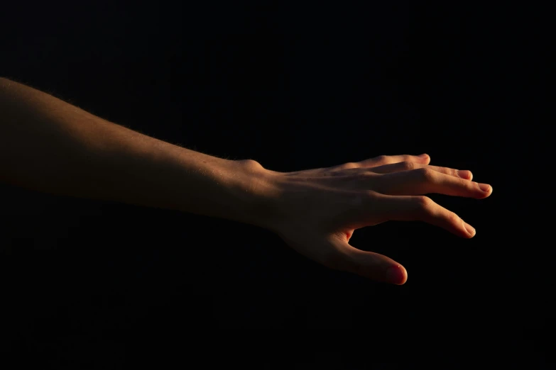 a hand with a light on it against a black background