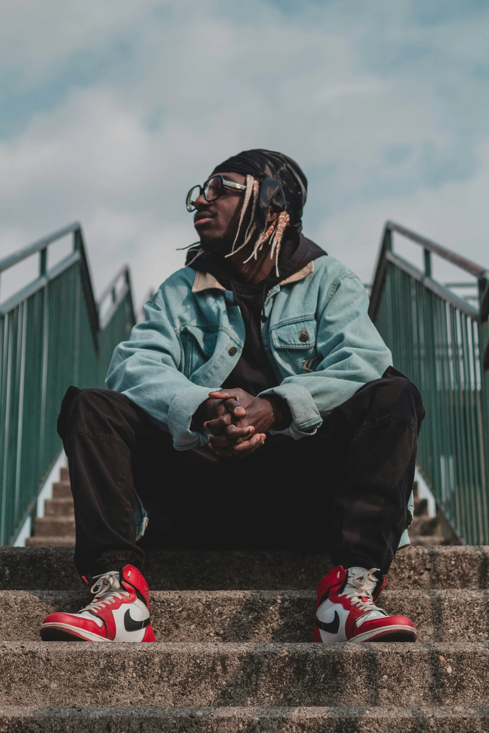 a man sits on the steps wearing sneakers