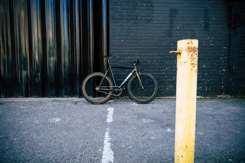 a bicycle parked next to a wooden pole