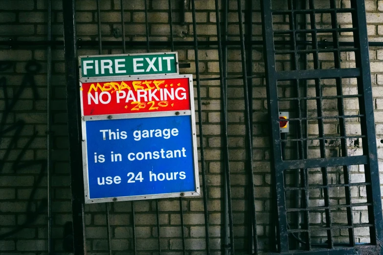 a fire exit sign that has a blue sign underneath it