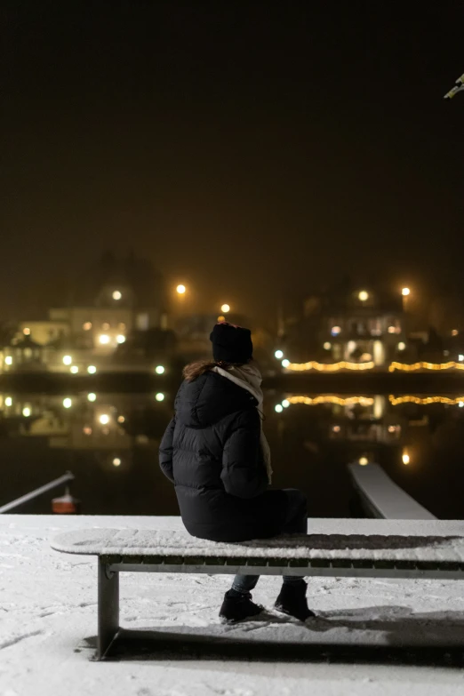 a person sitting on a bench in the snow