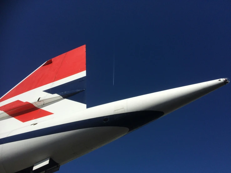 the tail section of a jet airplane against a blue sky