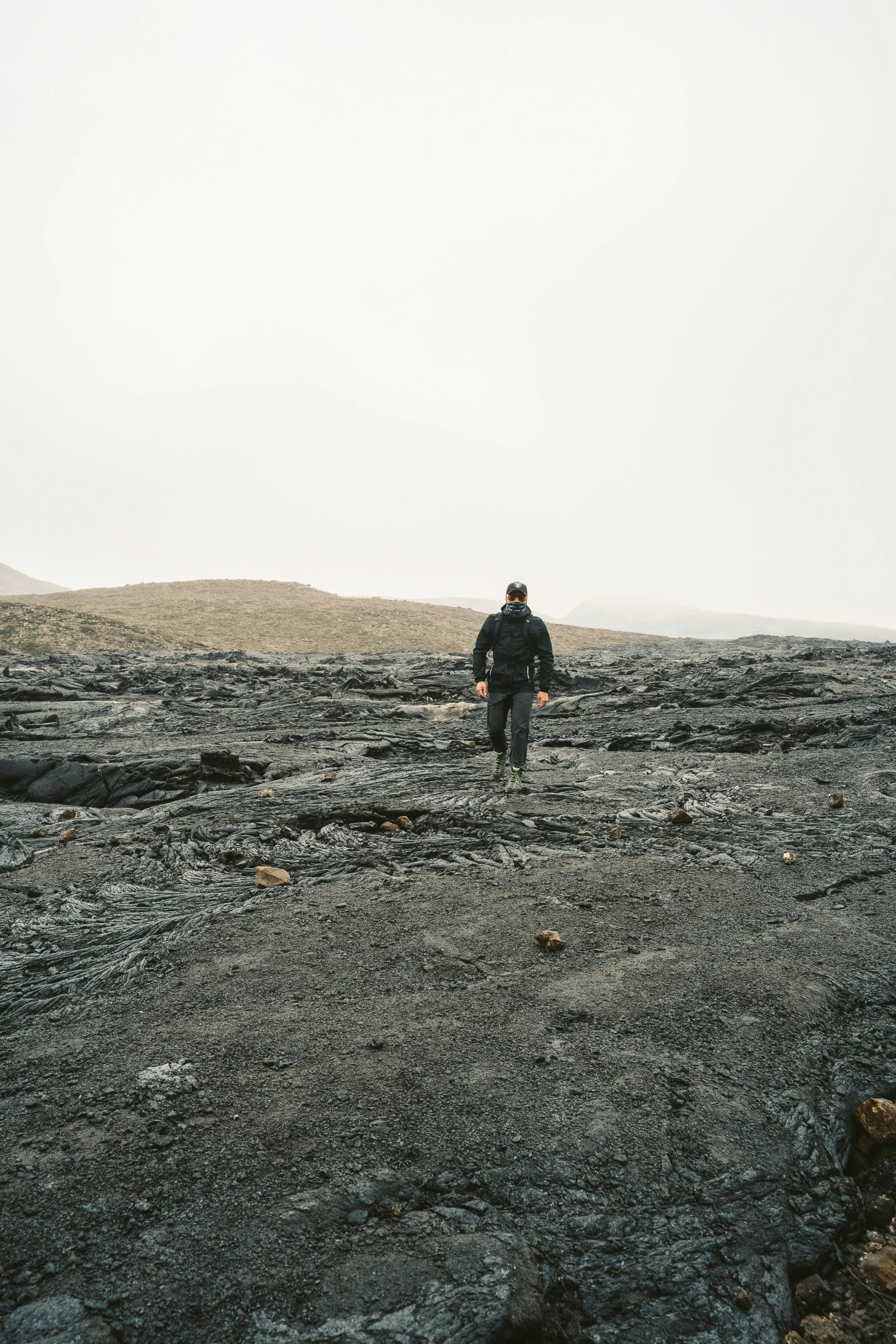 a man stands on a rocky area in the mountains