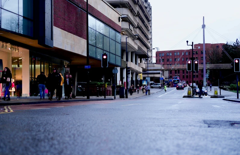 a city street with people walking and cars parked on it