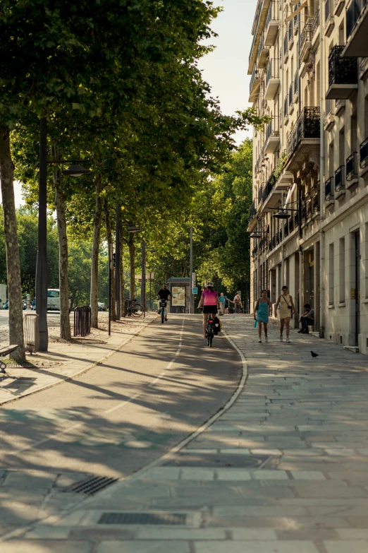 a group of people are riding bikes down a sidewalk