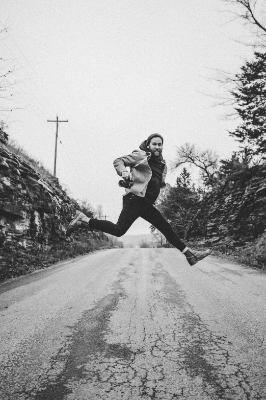 a man is running across the street near some rocks