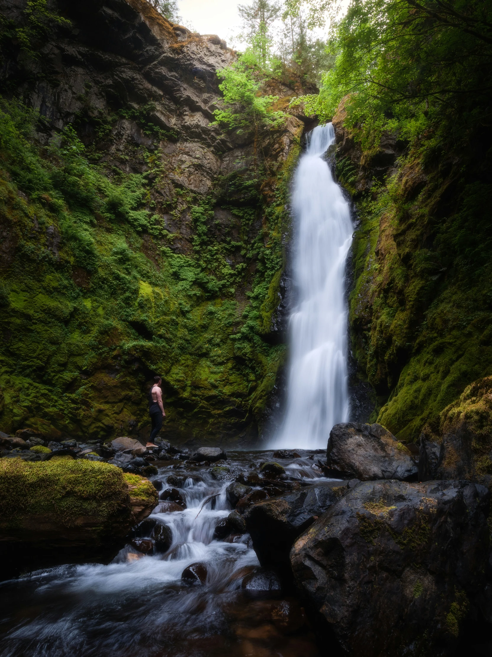 two people standing by the edge of a waterfall