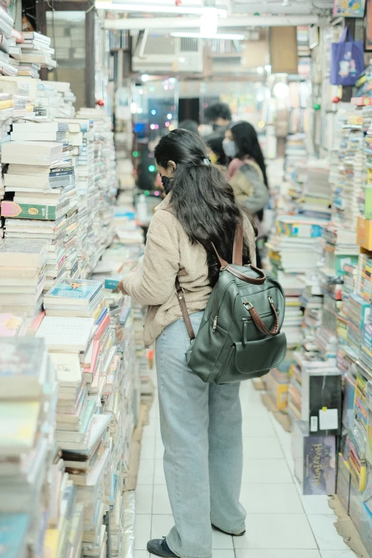 a woman standing in a aisle of books in a liry