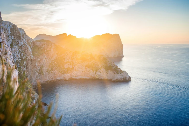 the sun is setting in a sunny rocky coast