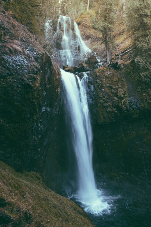 large waterfall in the middle of a forested area