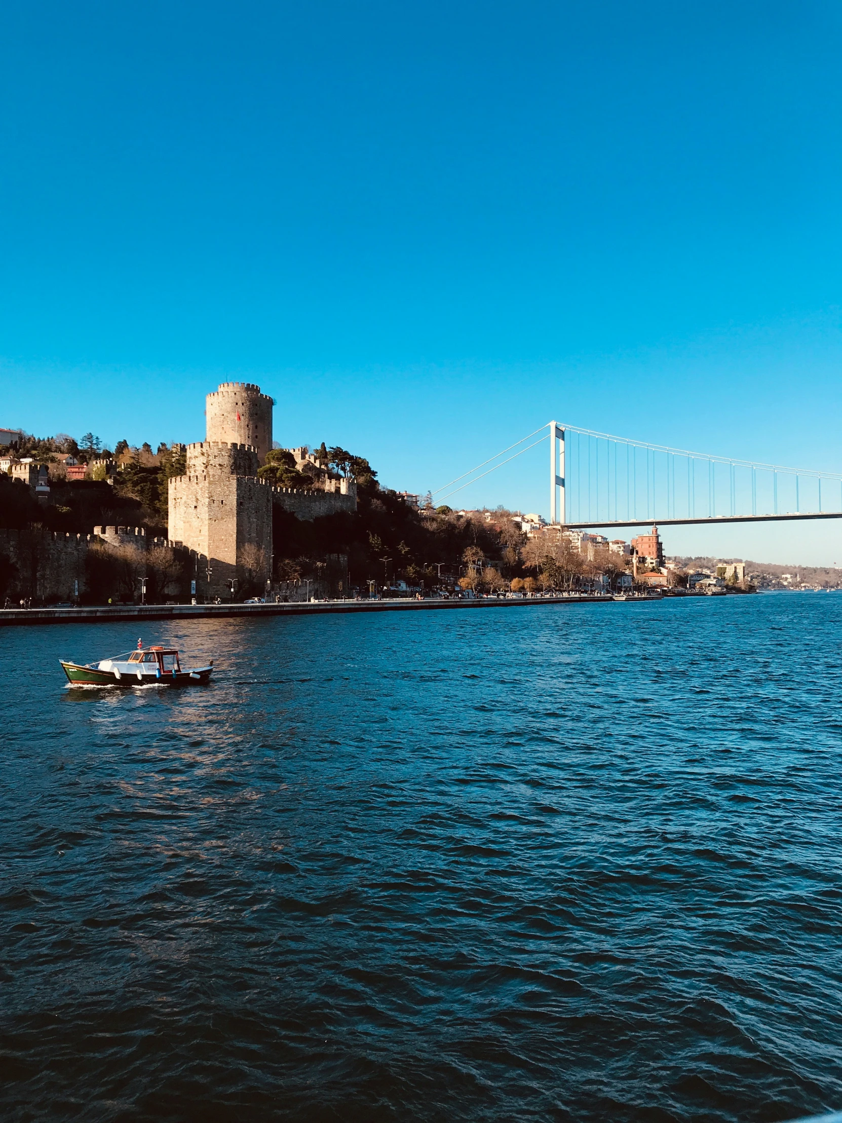 there is a boat sailing by the castle on the water